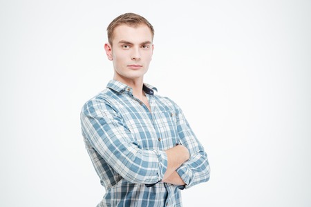 Confident attractive young man standing with arms crossed over white backgroundの写真素材