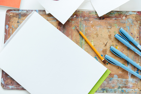 Top view of blank sketchbook, pencil and gel ink pens on the table of artistの写真素材