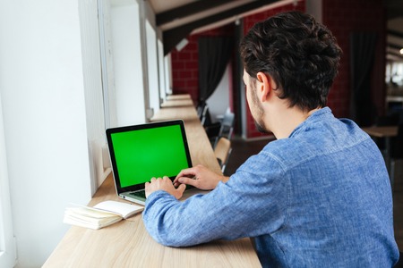 Man using laptop computer with blank screen in officeの写真素材