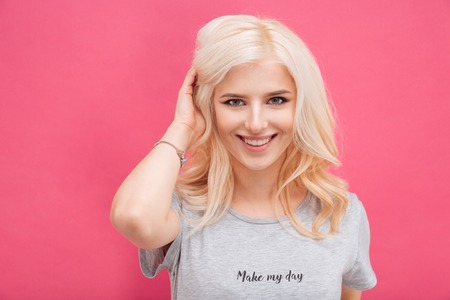Portrait of a happy pretty woman looking at camera over pink backgroundの写真素材