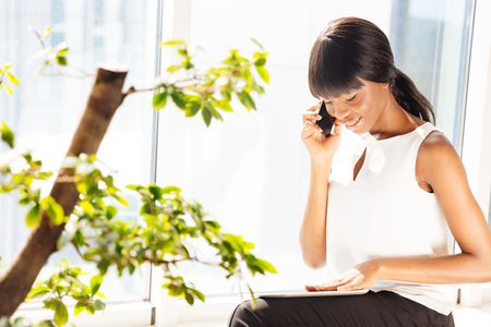 Happy businesswoman talking on the phone in officeの写真素材