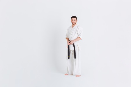 Full length portrait of a man in kimono standing isolated on a white backgroundの写真素材