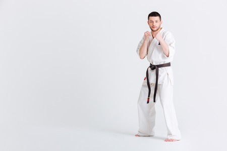 Man in kimono standing in fight stance isolated on a white backgroundの写真素材