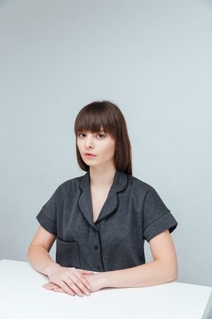 Serious casual woman looking at camera isolated on a white background