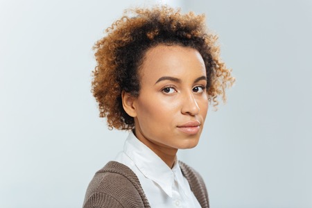 Closeup of beautiful african american young businesswoman with curly hair over white backgroundの写真素材