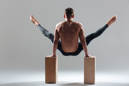 Fitness man workout on wooden boxes isolated on a white backgroundの写真素材