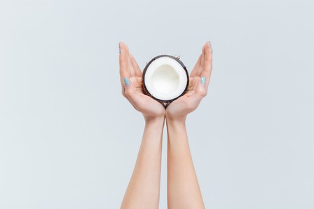 Female hands holding coconut isolated on a white backgroundの写真素材