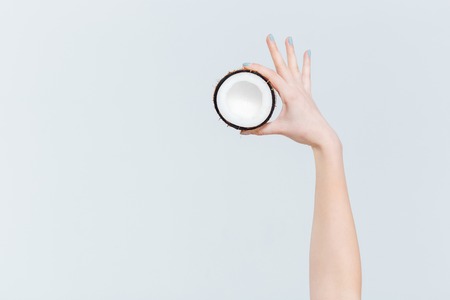 Female hand holding coconut isolated on a white backgroundの写真素材