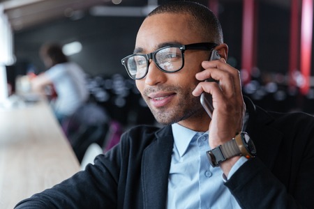 Close-up portrait of smiling cheerful businessman with cell phone