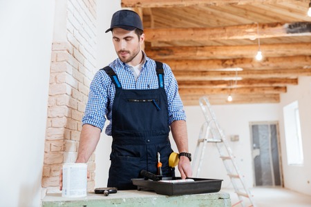 Casual builder going to paint walls indoorsの写真素材