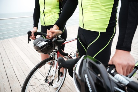 Closeup of couple with bikes walking and holding hands
