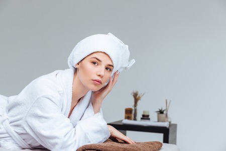 Portrait of pretty woman in bathrobe and towel lying in spa salonの写真素材