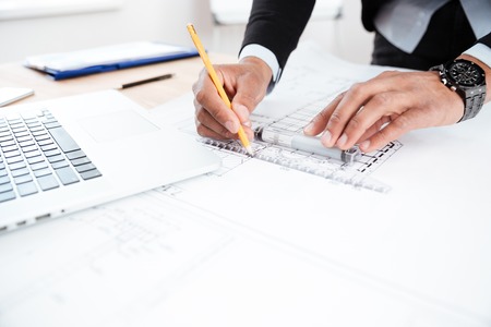 Close-up of businessman hands pointing pen to chart at officeの写真素材