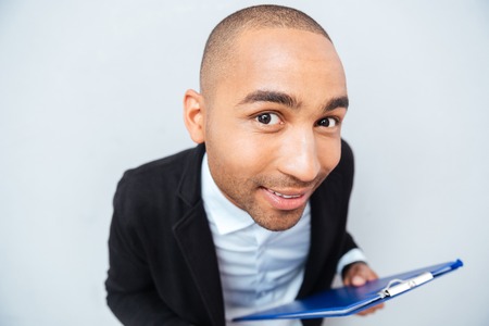 Closeup of smiling amusing african american young man holding clipboard