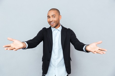 Modern young handsome happy african man smiling on isolated gray backgroundの写真素材