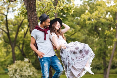 Happy young couple standing and laughing outdoorsの写真素材
