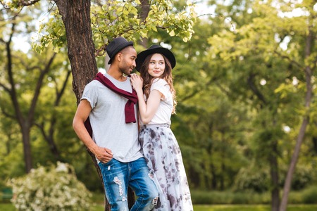 Portrait of beautiful young couple standing together in parkの写真素材