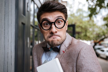 Close-up portrait of a funny nerd man wearing eyeglasses outdoors