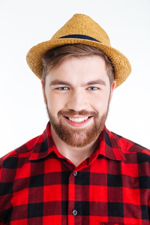Close-up portrait of a smiling handsome bearded man in a hat isolated on the white background
