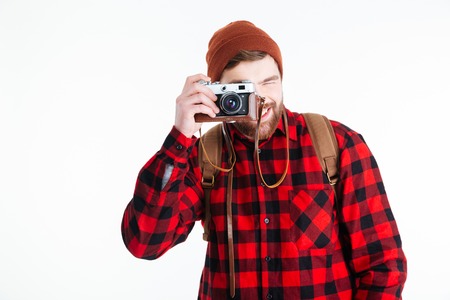 Happy casual man making photo on camera isolated on a white backgroundの写真素材