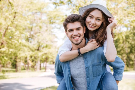 Portrait of a happy young smiling couple having fun outdoors in the parkの写真素材