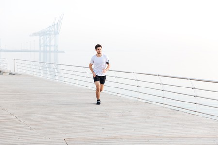Handsome man athlete running outdoors in the morning