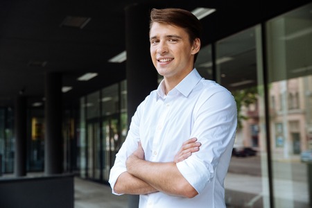 Confident successful young businessman standing with arms crossedの写真素材