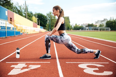 Pretty young woman athlete working out on stadiumの写真素材