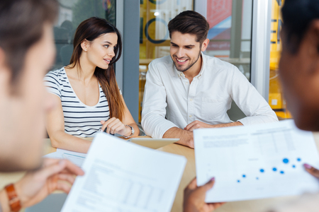 Smiling young business team sitting and making report in officeの写真素材
