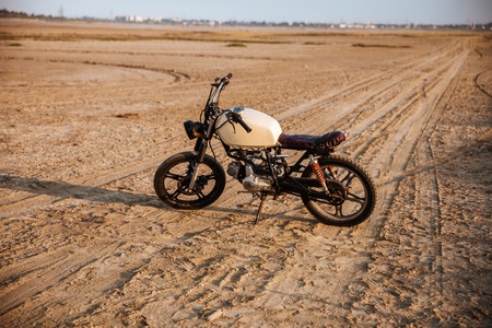 Retro motorcycle standing in the desertの写真素材