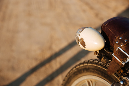 Close-up view on retro motorcycle headlights on the desert backgroundの写真素材
