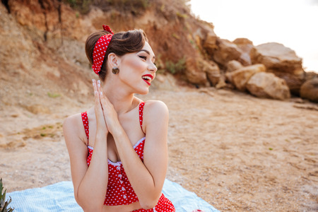 Beautiful sexy girl pin up in a bright bikini resting at the beachの写真素材