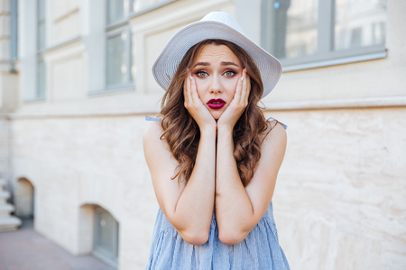 Portrait of a sad cute brunette girl looking away outdoorsの写真素材