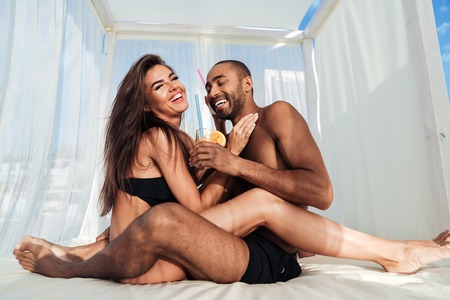 Young beautiful multiracial couple in love having fun at the beachの写真素材