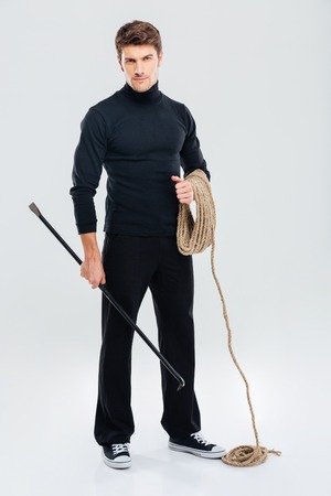 Full length of man offender with rope and crowbarの写真素材