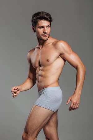 Handsome attractive man in underwear posing isolated on a gray backgroundの写真素材