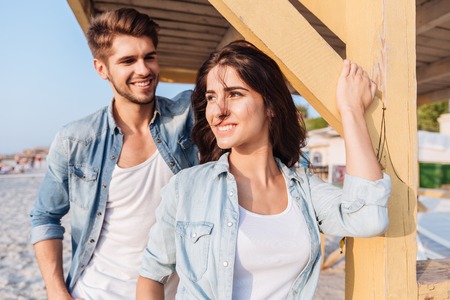 Beautiful young smiling couple in love standing at the beach houseの写真素材