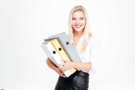 Cheerful businesswoman standing and holding folders over white backgroundの写真素材