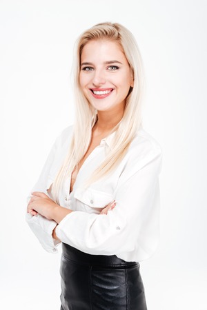 Happy pretty young businesswoman standing with arms crossed over white backgroundの写真素材