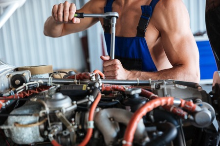 Cropped image of a repair man hands fixing engine on a planeの写真素材