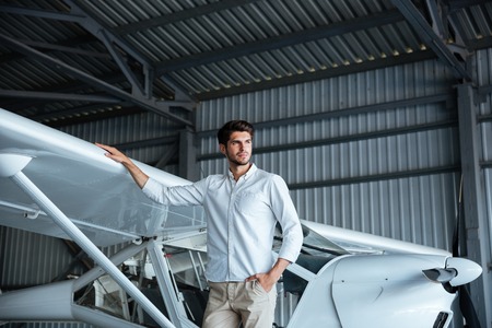 Portrait of handsome young man standing near smal airplaneの写真素材