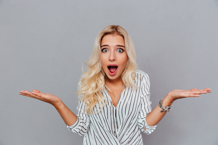 Portrait of surprised woman with mouth open standing isolated on a white backgroundの写真素材