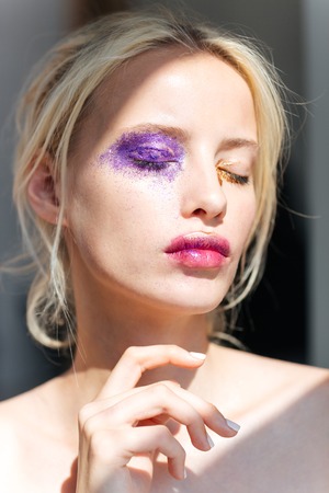Beautiful young woman with bright fashion makeup and eyes closed