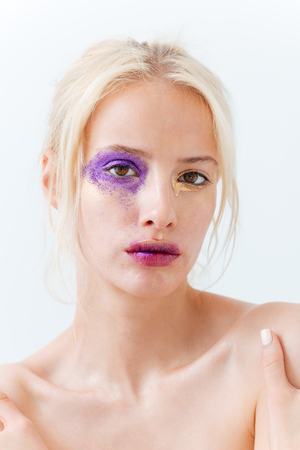 Beauty portrait of blonde young woman with fashion makeup over white backgroundの写真素材