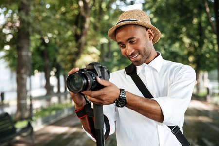 Beautiful black man in park with cameraの写真素材