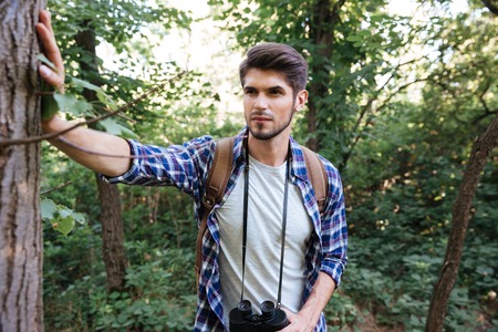 Front view of man with backpack in forest. near the treeの写真素材