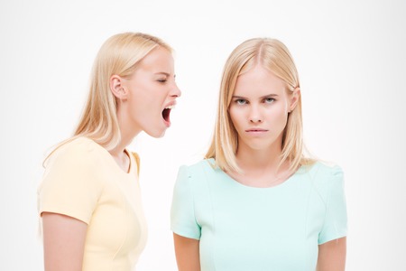 Picture of two young ladies swear. Isolated over white background.の写真素材