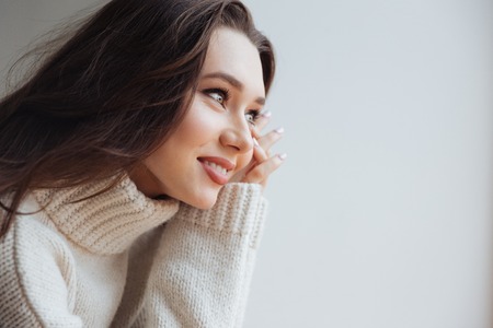 Side view of young model in sweater near the window. in profile.の写真素材