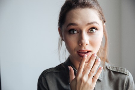 Attractive surprised woman in shirt. looking at camera. isolated gray backgroundの写真素材