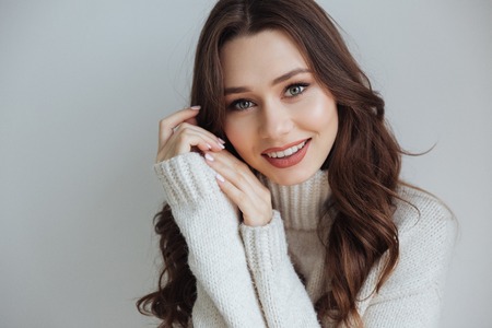 Smiling model in sweater in studio. looking at camera. isolated gray backgroundの写真素材
